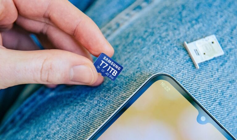 Samsung T7 microSD im Alltag – Speicherkarte neben Smartphone Hand hält eine Samsung T7 microSD-Karte neben einem Smartphone auf Jeansstoff