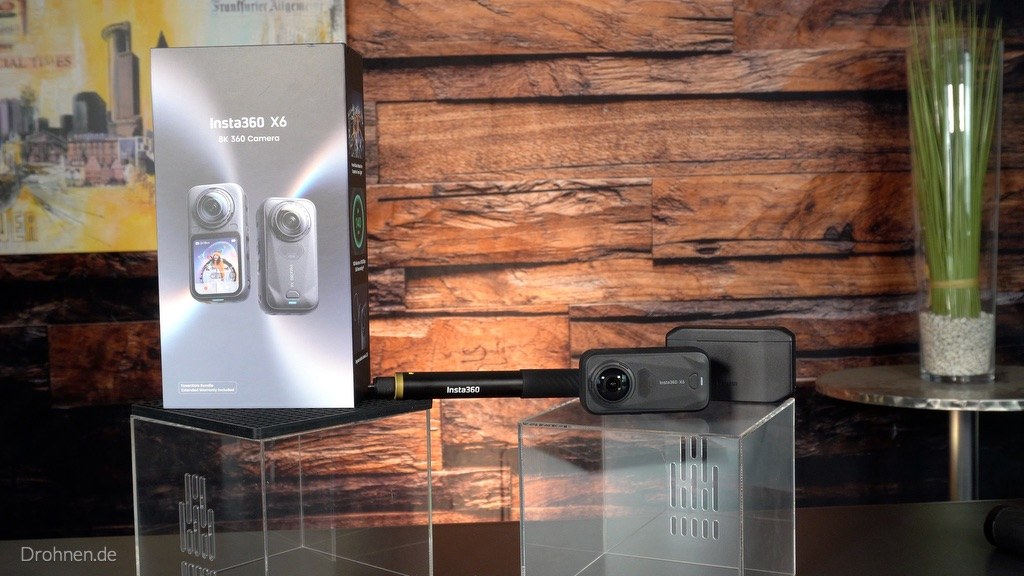 Insta360 X6 mit Originalverpackung und Selfie-Stick Insta360 X6 liegt neben ihrer Verpackung und einem zusammengeschobenen Selfie-Stick
