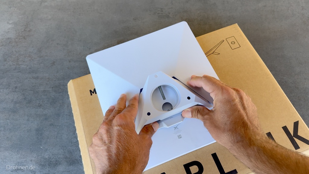 Dreieckiger Rohradapter wird auf die rückseitige Aufnahme des Starlink Mini gesetzt.