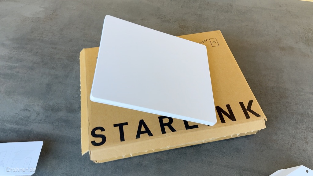 Weiße Antennenfläche des Starlink Mini auf dem braunen Starlink-Karton.