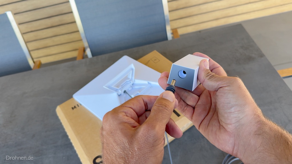 Runder DC-Stecker wird vor die Buchse des Starlink-Mini-Netzteils gehalten.