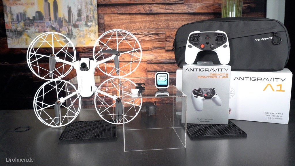 Antigravity A1 mit montiertem Propellerschutz neben Umhängetasche, Watch Remote und Verpackung