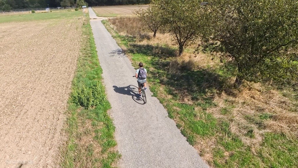 Luftaufnahme: Radfahrer in der Kurve, verfolgt von der Antigravity A1