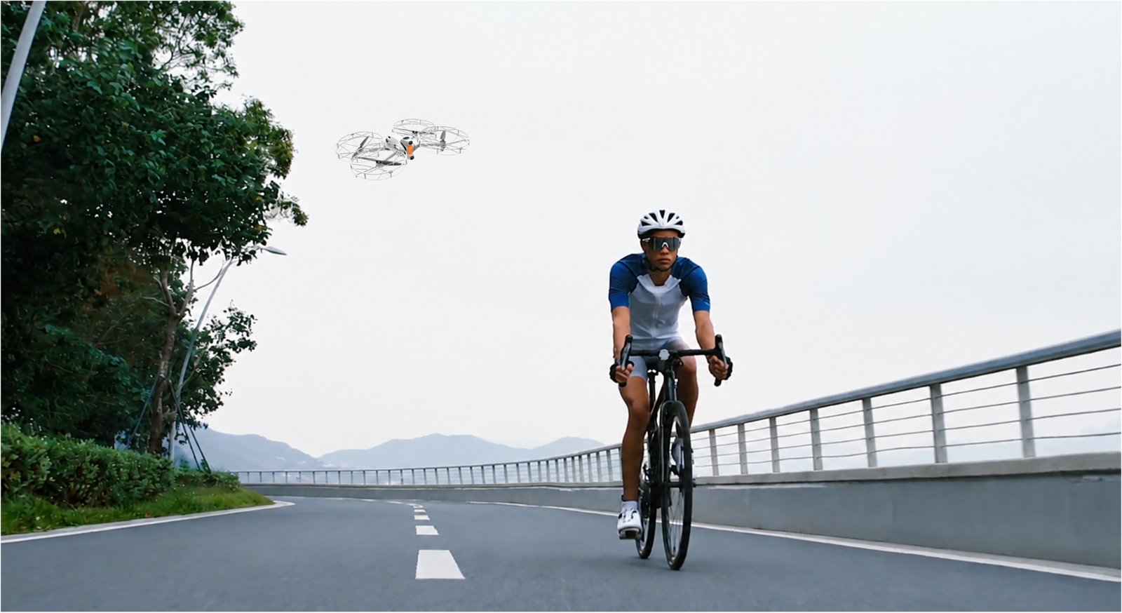 Antigravity A1 folgt einem Rennradfahrer auf einer Brücke