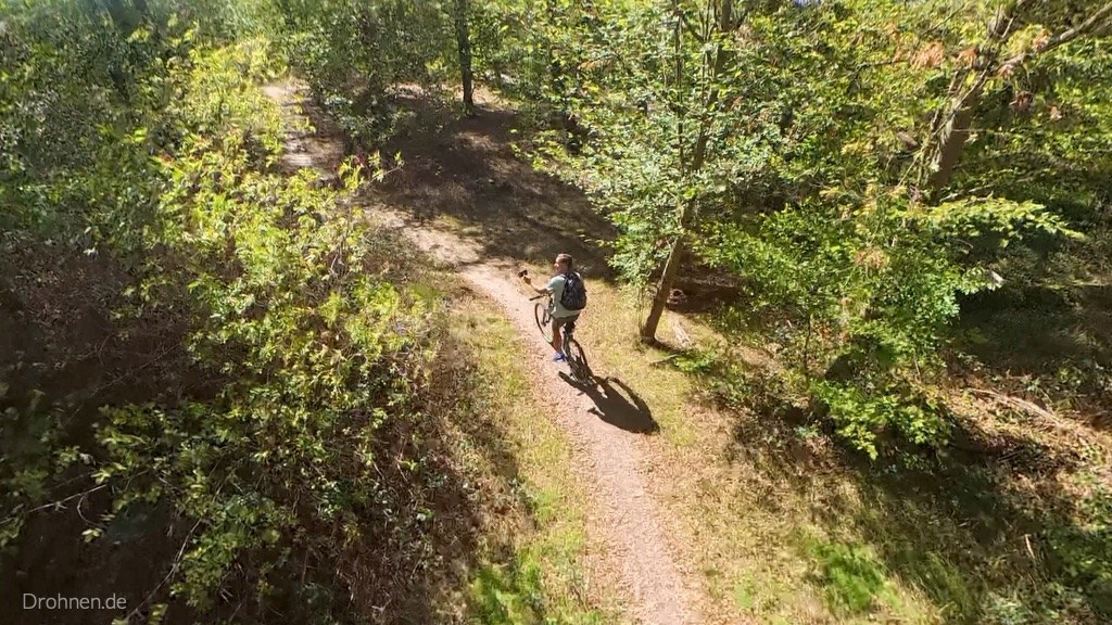Luftaufnahme: Antigravity A1 folgt Mountainbiker auf Waldweg