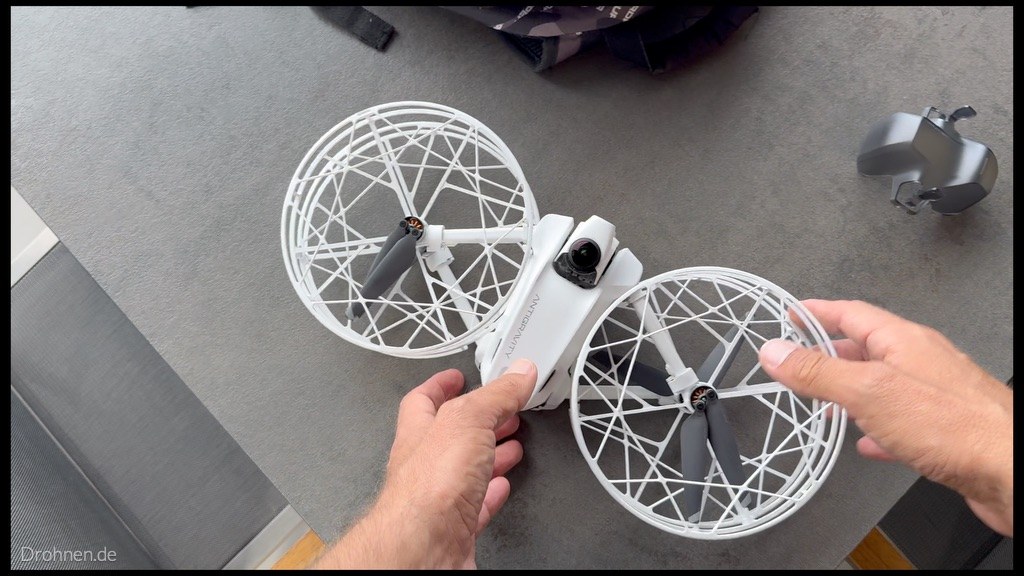 Antigravity A1 mit halb eingeklappten Armen und montiertem Propellerschutz, Linsenschutz aufgesetzt