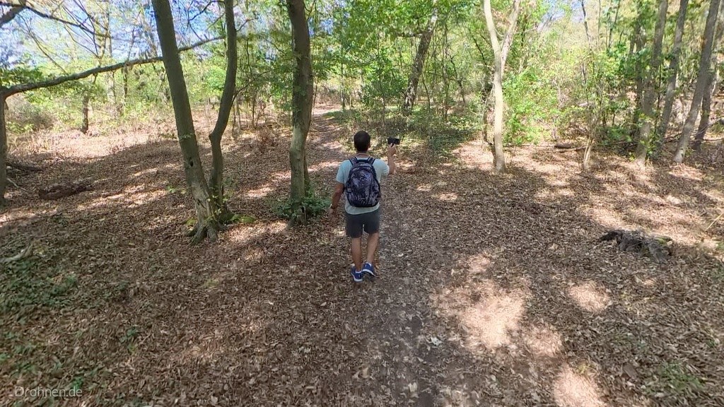 Person geht zu Fuß durch den Wald, Antigravity A1 folgt
