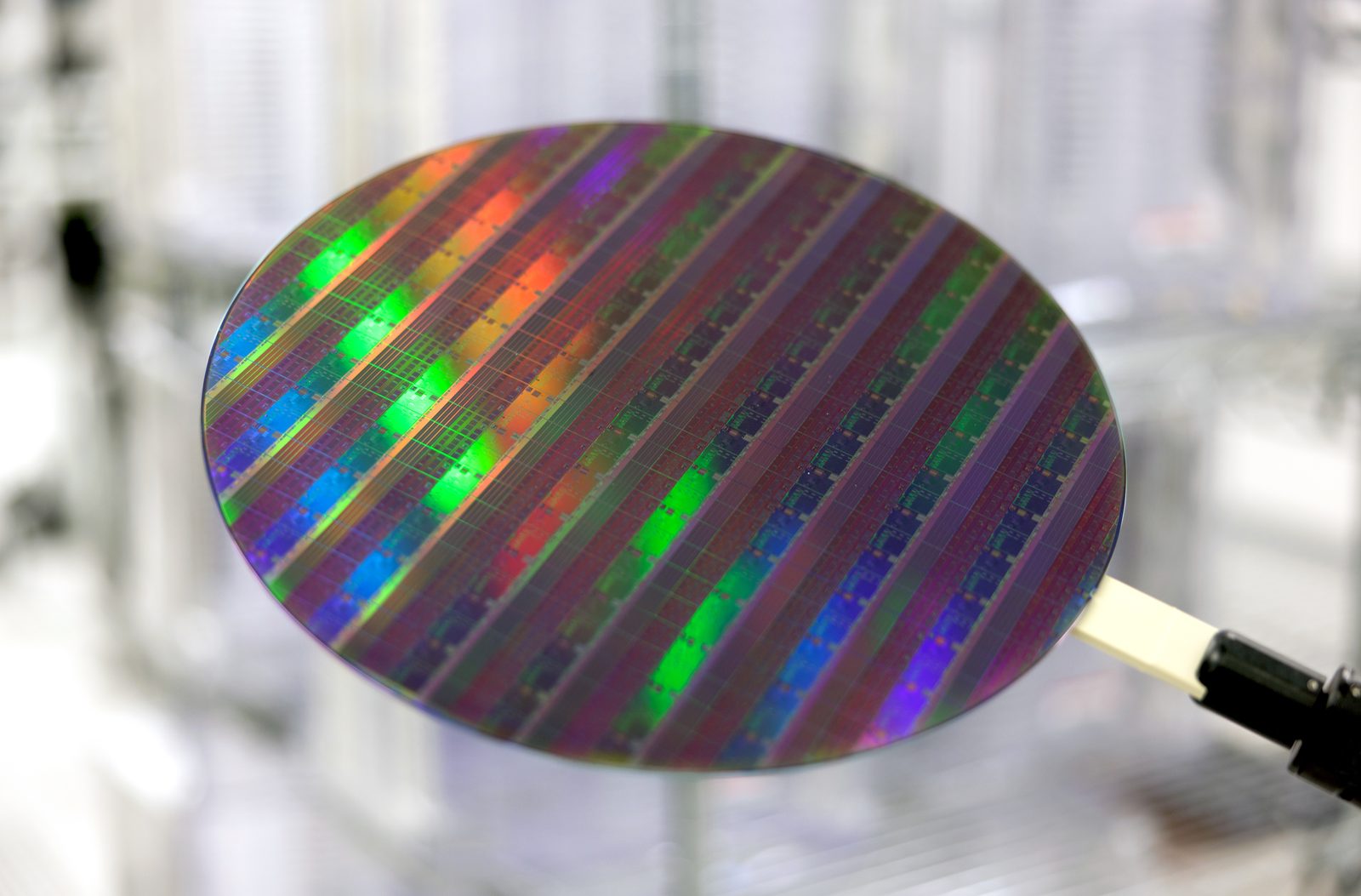 Silizium-Wafer mit regenbogenfarben schimmernden Chipstrukturen in Nahaufnahme