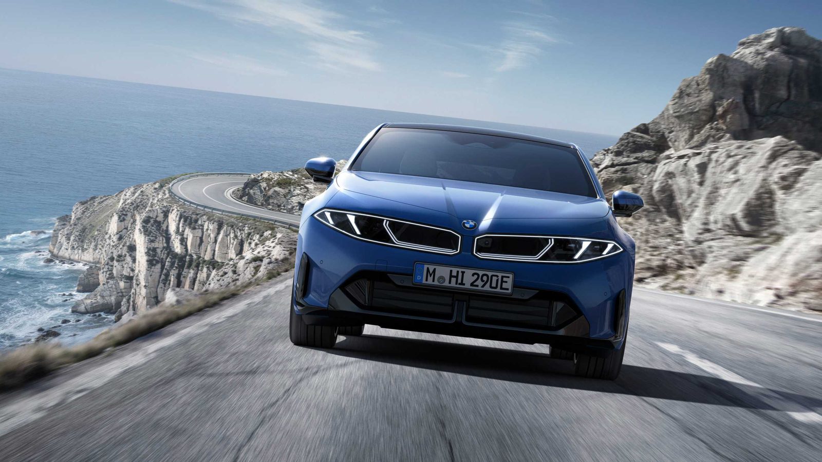 Frontansicht des blauen BMW i3 50 xDrive mit schmalen Scheinwerfern auf einer Küstenstraße