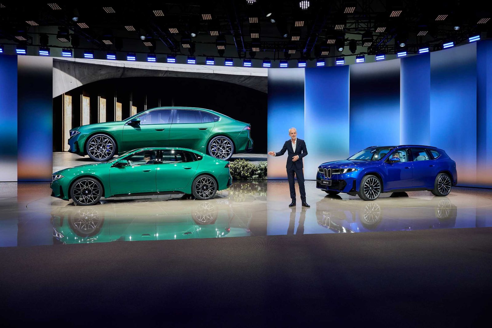 Präsentation der Langversionen von BMW i3 und iX3 auf der Auto China in Peking mit zwei grünen Limousinen und einem blauen SUV