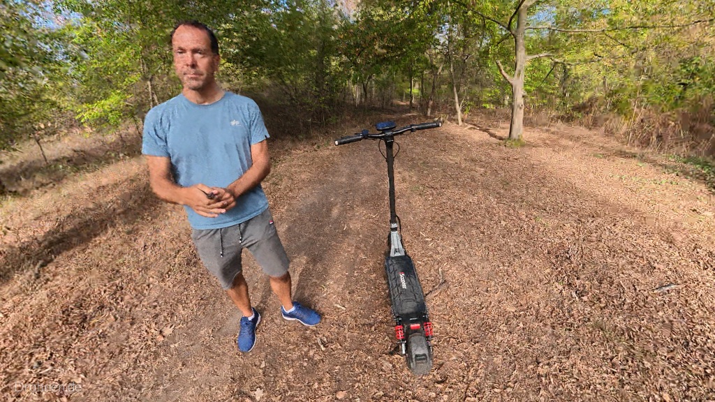 Tester neben dem abgestellten iScooter iX7 Pro im Wald, Scooter von hinten