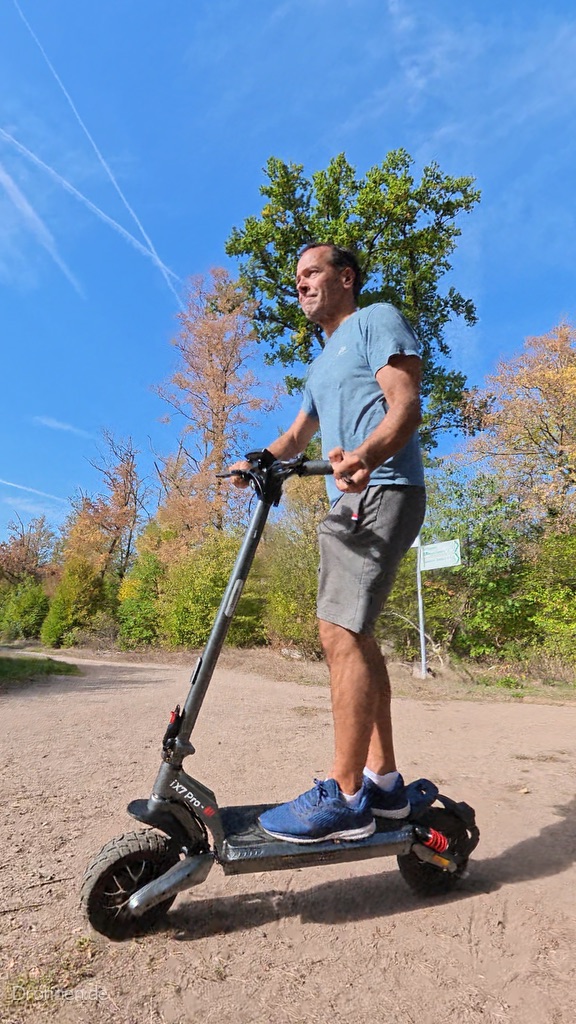 iScooter iX7 Pro in Seitenansicht mit Fahrer auf einem sandigen Weg