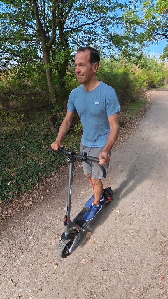 iScooter iX7 Pro in Fahrt auf einem fein geschotterten Weg, Blick von schräg oben