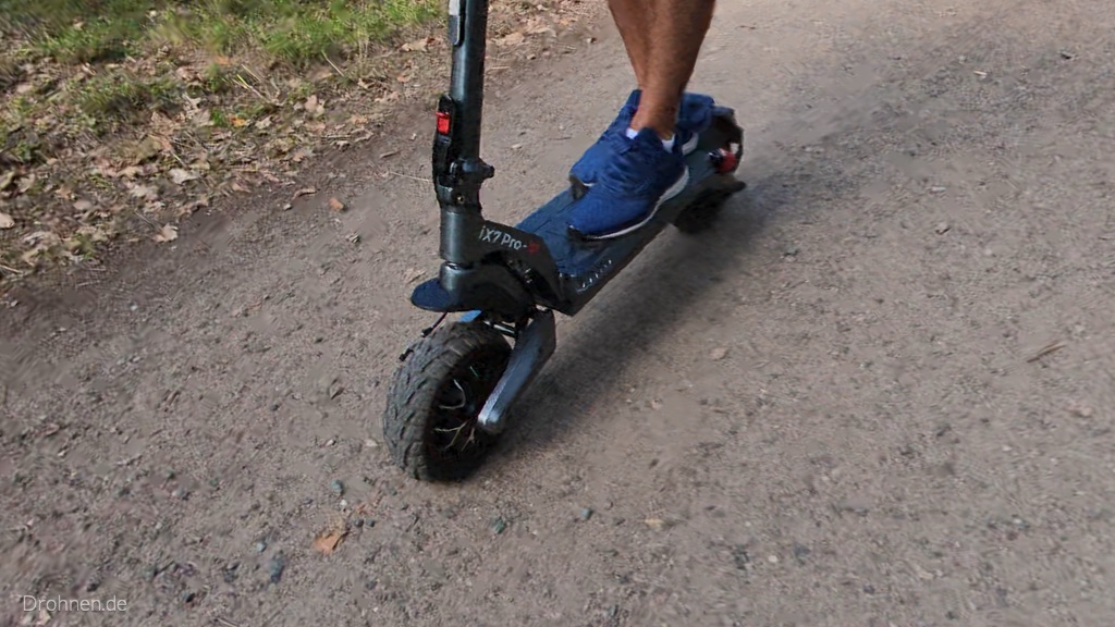 Detail des iScooter iX7 Pro: Vorderrad, Schriftzug iX7 Pro und Trittbrett in Fahrt