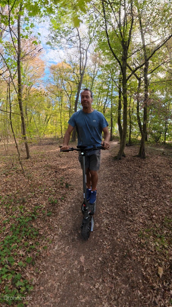 iScooter iX7 Pro frontal auf einem laubbedeckten Waldpfad