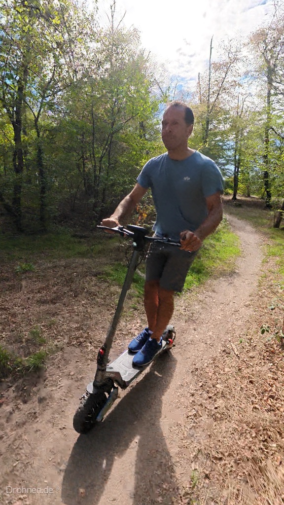 iScooter iX7 Pro von schräg vorn auf einem Waldweg, grob profilierter Vorderreifen