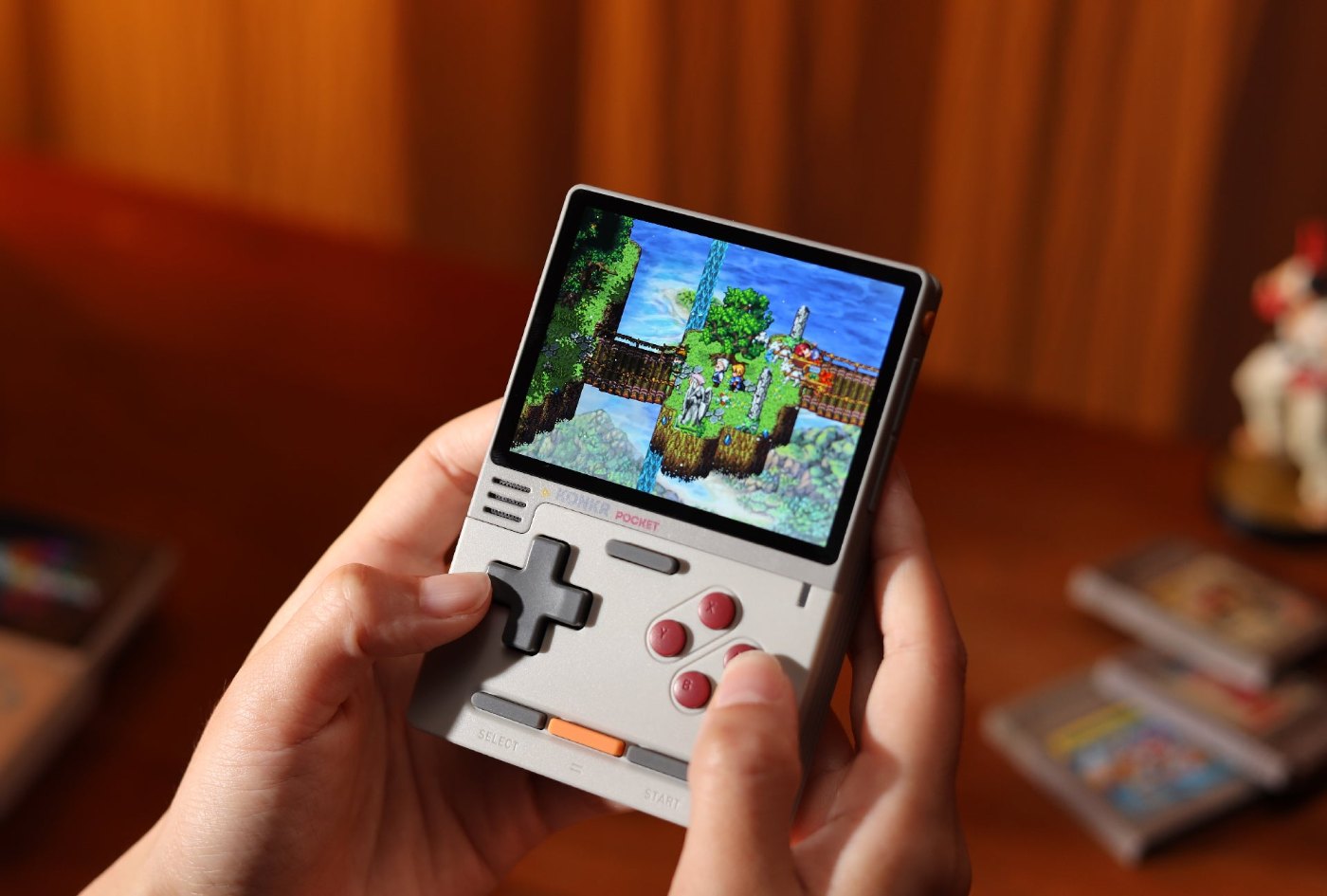 Hände halten einen KONKR Pocket Block hochkant, auf dem Display läuft ein Retro-Spiel