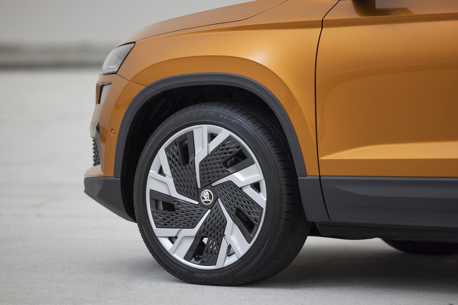 Vorderrad und Kotflügel eines orangefarbenen Škoda Karoq