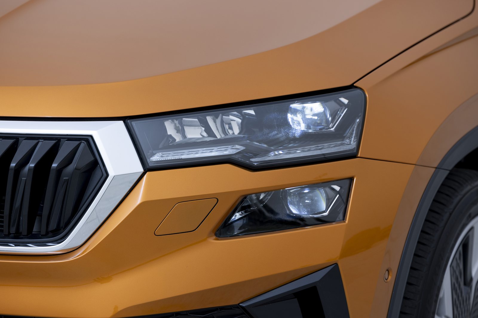 Scheinwerfer und Kühlergrill eines orangefarbenen Škoda Karoq