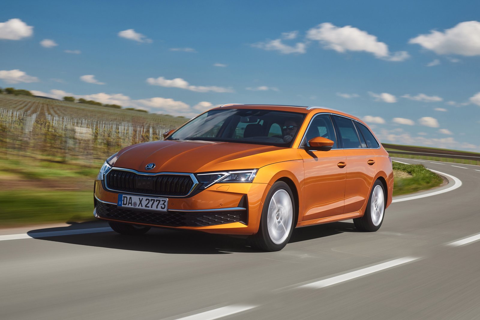 Orangefarbener Škoda Octavia Combi in schräger Frontansicht auf einer Landstraße
