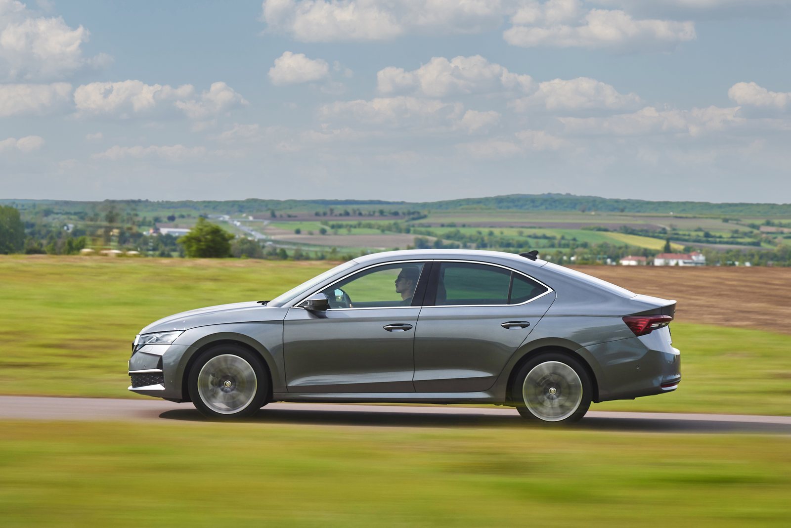 Grauer Škoda Octavia IV Facelift während der Fahrt in seitlicher Ansicht