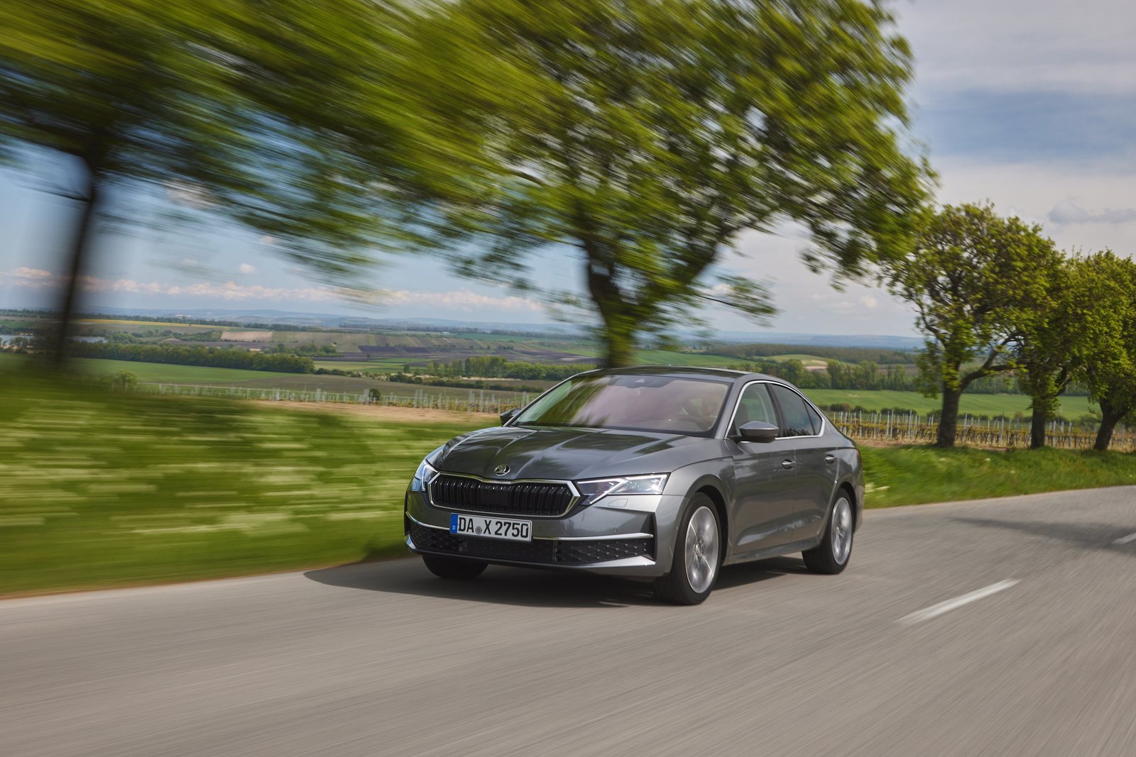 Grauer Škoda Octavia IV Facelift in schräger Frontansicht während der Fahrt