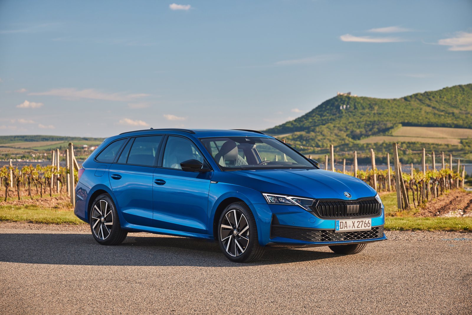 Blauer Škoda Octavia Sportline Combi in schräger Frontansicht vor Weinbergen