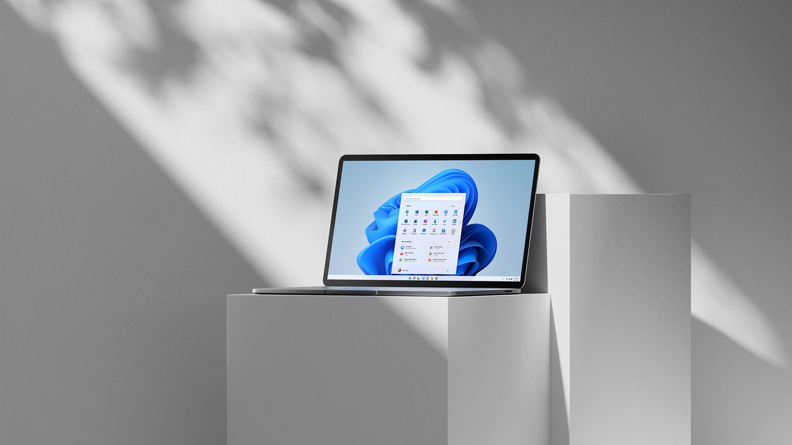 Offizieller Laptop-Render mit Microsoft Windows 11 auf dem Bildschirm in einem hellen Studio